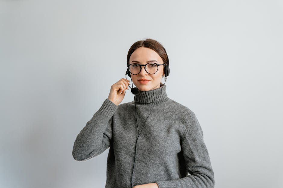 Smiling support agent wearing headset providing remote IT assistance in a modern office